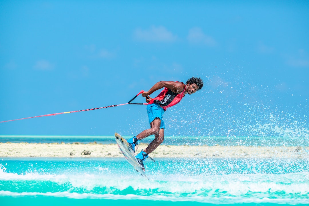 'man in red tank top doing water sports during daytime' man in red tank top doing water sports during daytime
