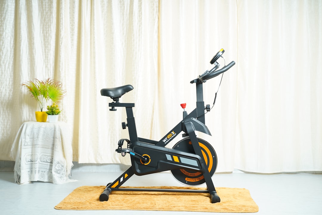 a stationary bike sits on a rug in front of a curtain