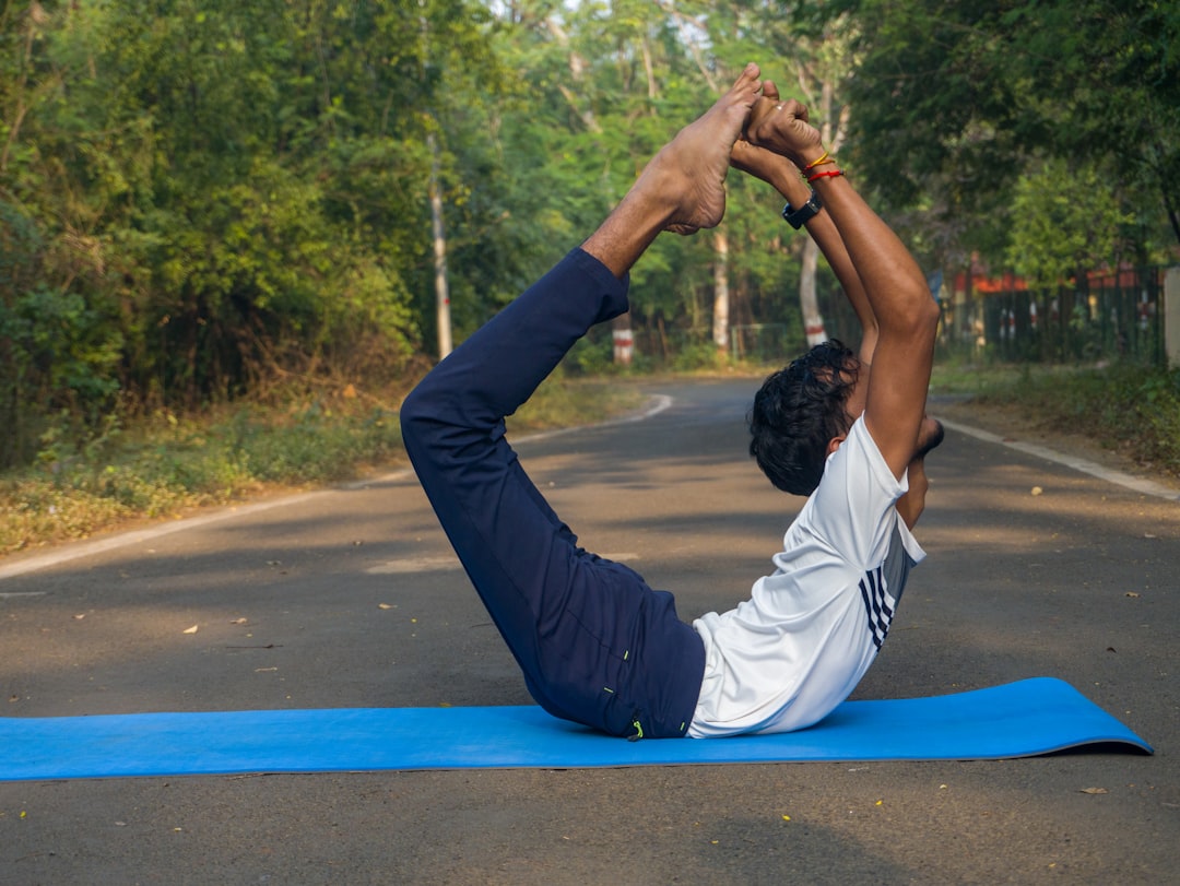 A man doing a yoga pose on a blue mat